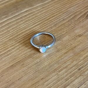 Tiny pearl like ring on a silver tone band that is size 7 1/2